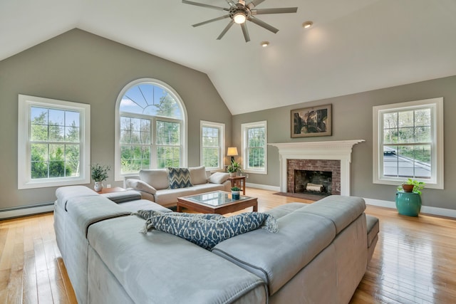 living area featuring healthy amount of natural light, baseboard heating, ceiling fan, vaulted ceiling, and recessed lighting
