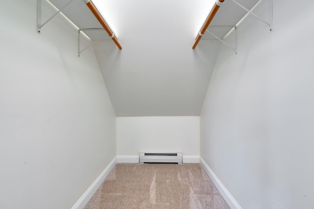walk in closet featuring a baseboard radiator, carpet flooring, and vaulted ceiling