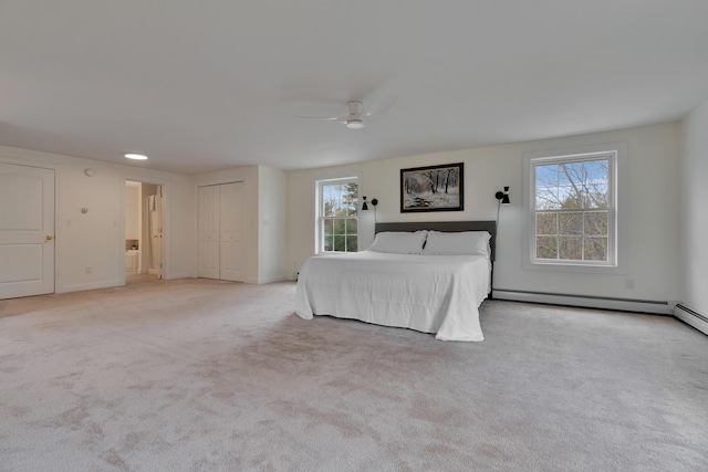 bedroom with multiple windows, carpet flooring, a baseboard radiator, and baseboards
