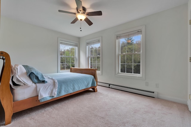 bedroom featuring a baseboard radiator, multiple windows, carpet floors, and ceiling fan