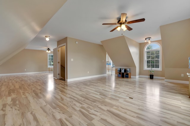 bonus room with a ceiling fan, light wood finished floors, lofted ceiling, and baseboards