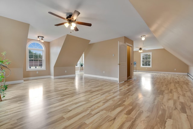 bonus room featuring ceiling fan, light wood-style flooring, baseboards, and vaulted ceiling