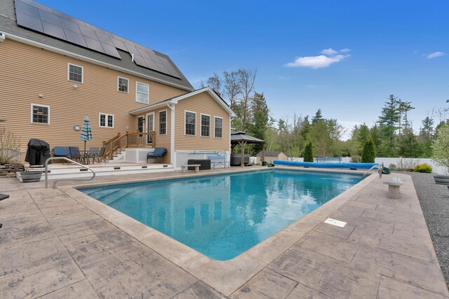 view of pool with a gazebo, a patio area, fence, and an outdoor living space