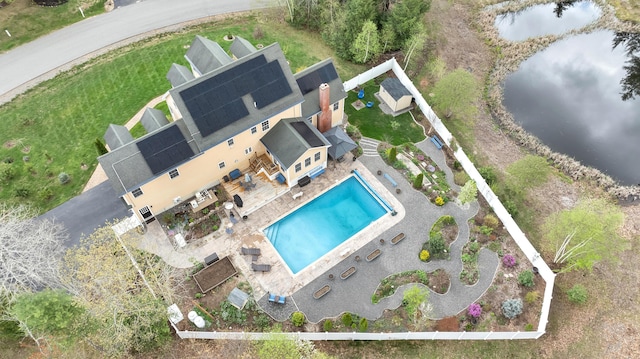 view from above of property featuring a pool area and a large body of water