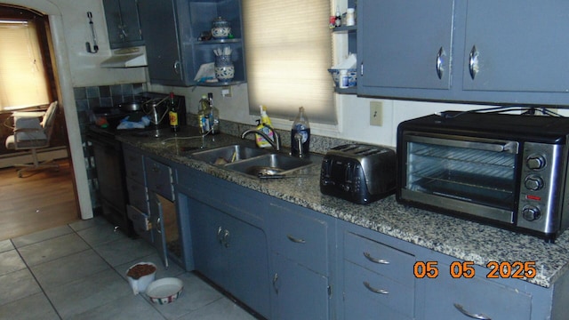20 Morgan St, Lincoln, ME 04457 - kitchen featuring a healthy amount of sunlight, under cabinet range hood, a sink, and blue cabinetry
