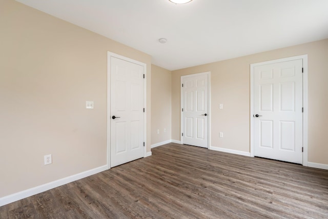 unfurnished bedroom with wood finished floors and baseboards