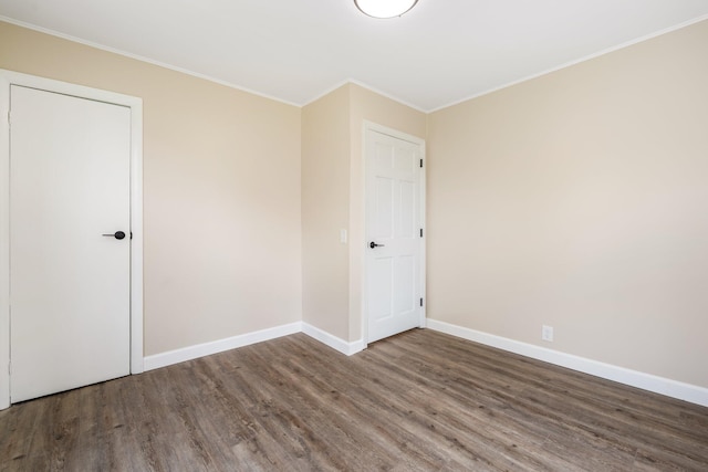 unfurnished bedroom featuring wood finished floors, ornamental molding, and baseboards