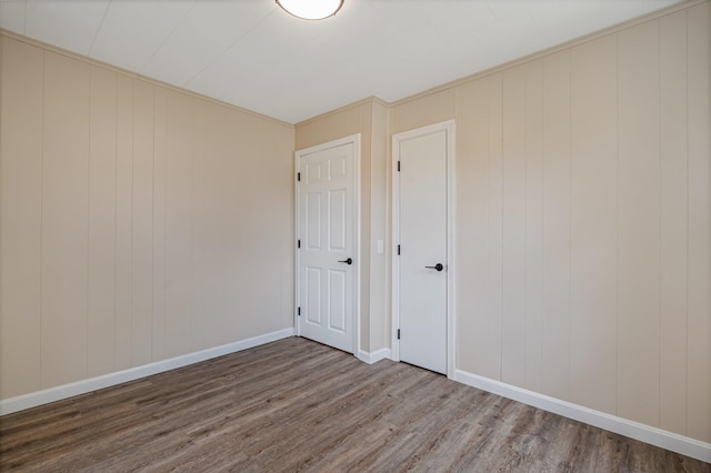 unfurnished bedroom featuring wood finished floors and baseboards