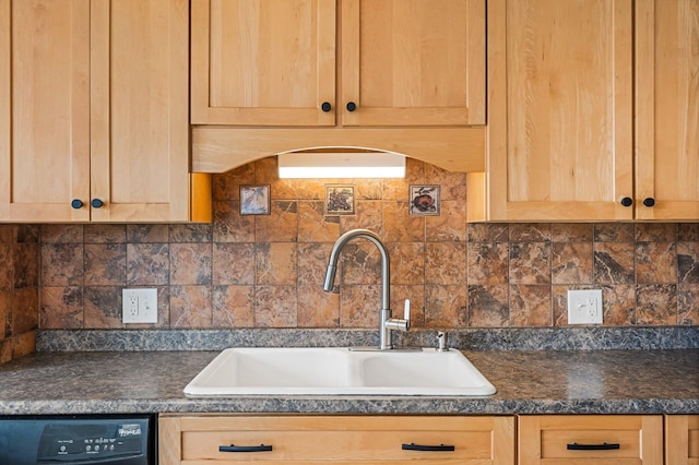 kitchen with a sink, light brown cabinetry, dishwasher, and dark countertops