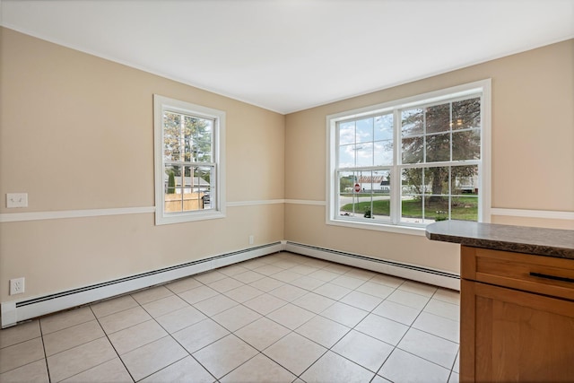 unfurnished room featuring a baseboard radiator and light tile patterned flooring