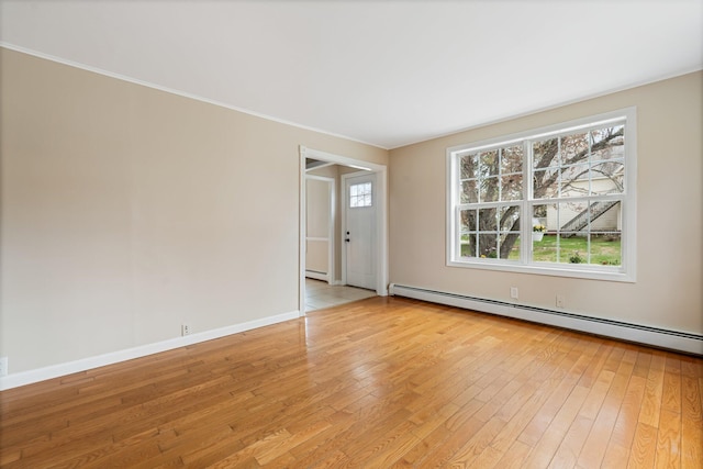 empty room featuring a baseboard heating unit, light wood-style floors, baseboards, and ornamental molding