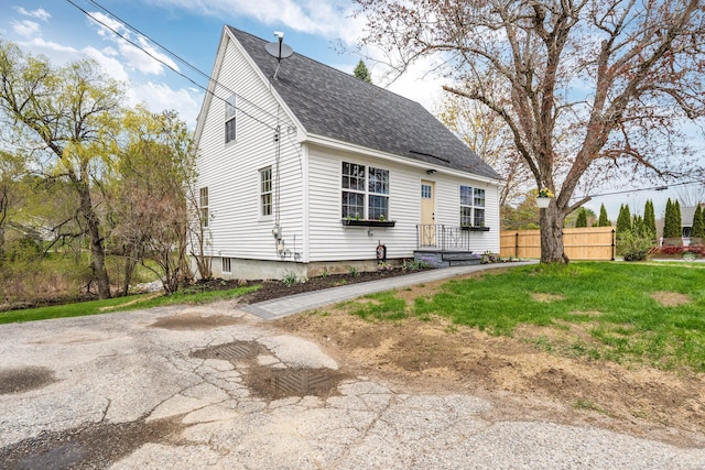 view of front of home with fence and roof with shingles