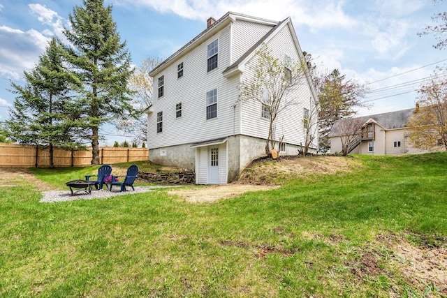 rear view of property featuring a fire pit and a chimney