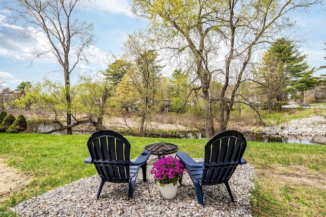 view of grassy yard featuring an outdoor fire pit