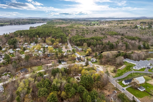 aerial view of property's location with a water and mountain view and a heavily wooded area