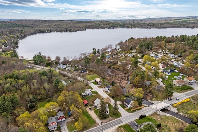 view of property location featuring a nearby body of water, a heavily wooded area, and nearby suburban area