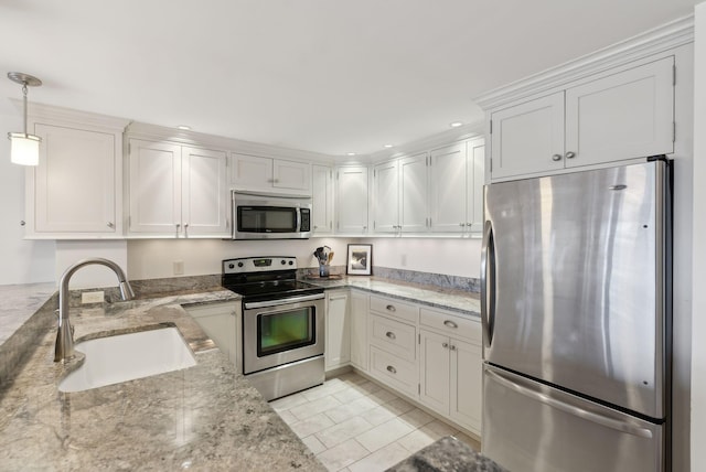 709 Chandlers Wharf Unit 709, Portland, ME 04101 - kitchen featuring stainless steel appliances, a sink, light stone counters, hanging light fixtures, and white cabinets