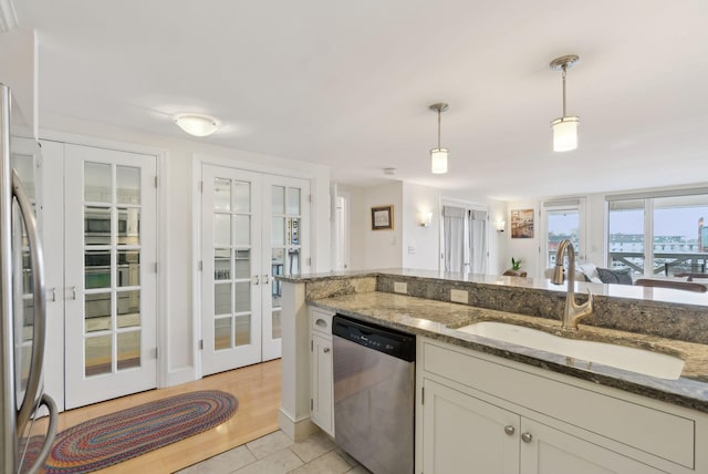 709 Chandlers Wharf Unit 709, Portland, ME 04101 - kitchen featuring stainless steel appliances, french doors, a sink, decorative light fixtures, and white cabinetry