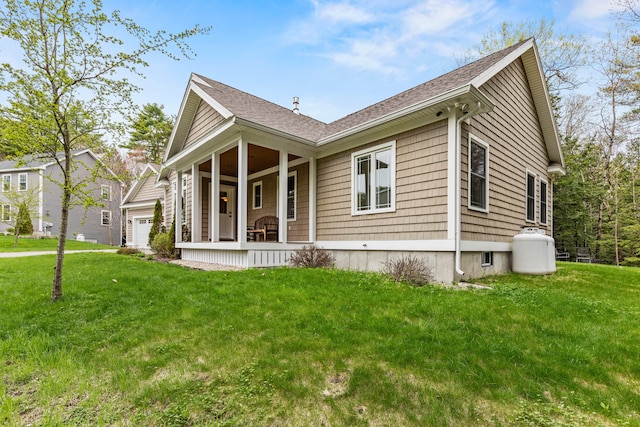 view of front of home featuring a porch, roof with shingles, a front lawn, and an attached garage