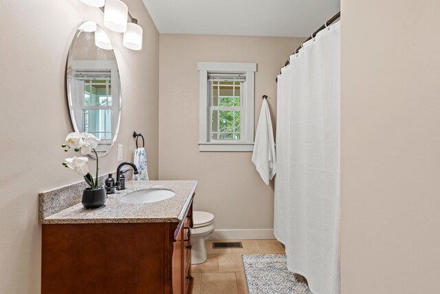 bathroom with toilet, vanity, visible vents, tile patterned flooring, and baseboards