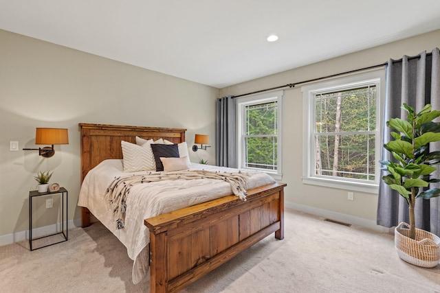 bedroom featuring light colored carpet, visible vents, and baseboards