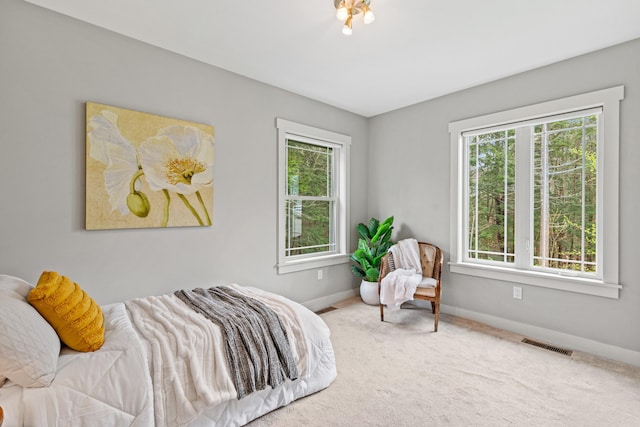 carpeted bedroom with multiple windows, visible vents, and baseboards