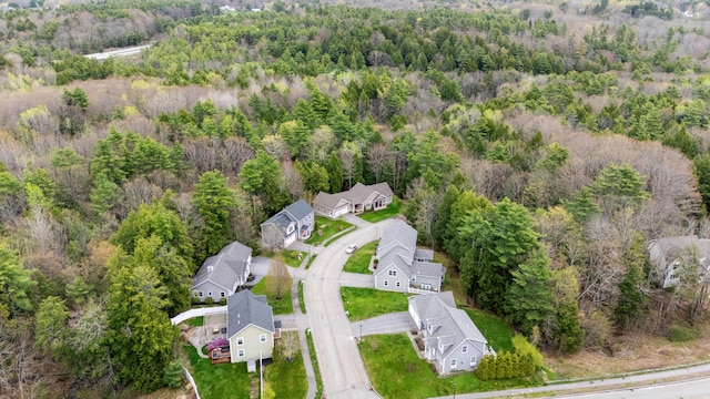 drone / aerial view with a wooded view and a residential view