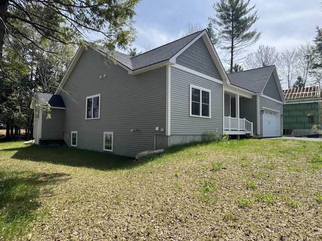 view of property exterior featuring a garage, a lawn, and a shingled roof