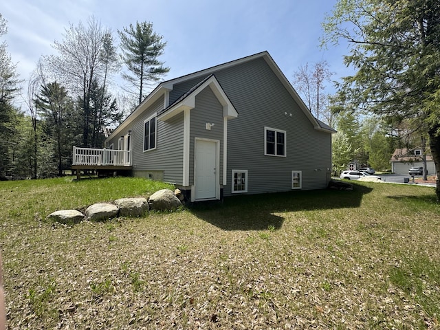 view of side of home with a wooden deck and a lawn