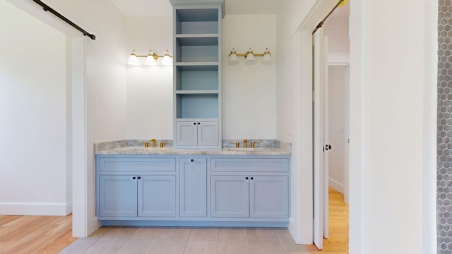 15 County Xing, Brunswick, ME 04011 - bathroom featuring baseboards, double vanity, a sink, and wood finished floors