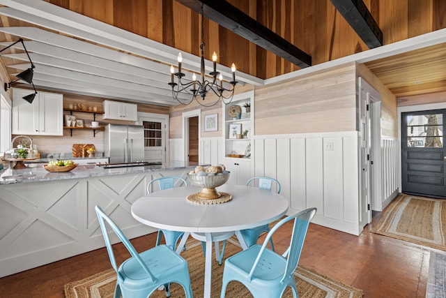 79 Snug Harbor Rd, Standish, ME 04084 - dining area with a chandelier, finished concrete floors, wooden walls, and wainscoting