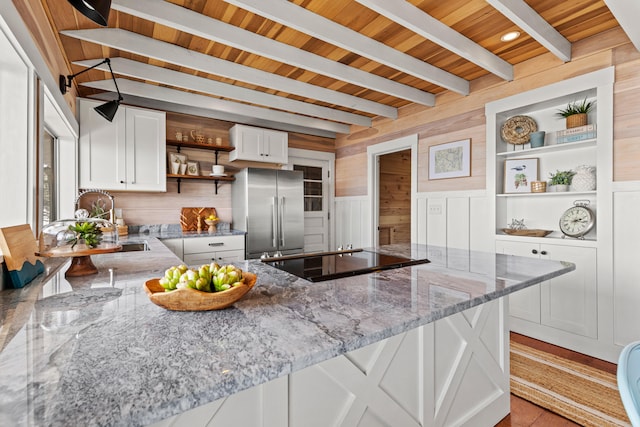 79 Snug Harbor Rd, Standish, ME 04084 - kitchen with open shelves, black electric stovetop, high end refrigerator, wooden walls, and light stone countertops
