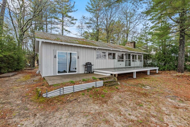 79 Snug Harbor Rd, Standish, ME 04084 - rear view of house with a deck, board and batten siding, a chimney, and a shingled roof