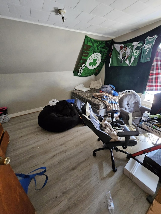 bedroom featuring vaulted ceiling, baseboards, and wood finished floors