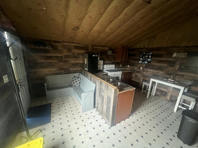 51 Pond Rd, Bradford, ME 04410 - bar with a sink, lofted ceiling, wood walls, light floors, and white gas stove