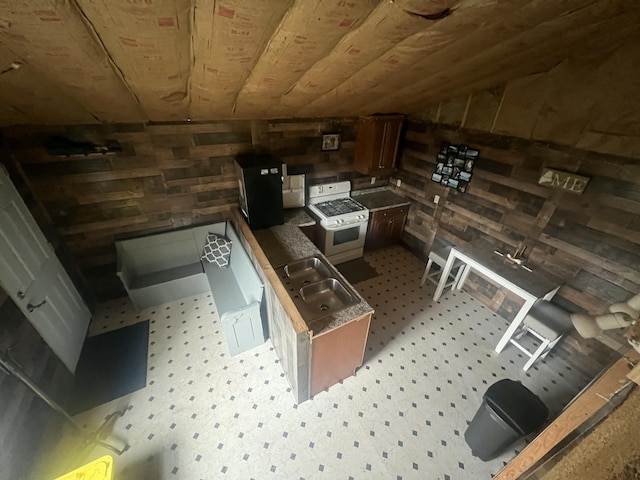 51 Pond Rd, Bradford, ME 04410 - kitchen with a sink, wooden walls, light floors, and white range with gas stovetop