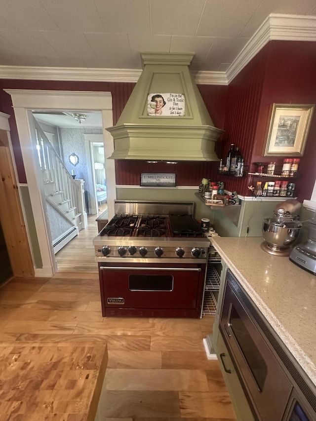 5 Cone St, East Millinocket, ME 04430 - kitchen with appliances with stainless steel finishes, light wood-type flooring, custom range hood, ornamental molding, and a baseboard heating unit