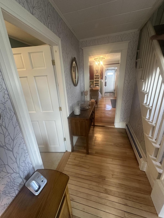 5 Cone St, East Millinocket, ME 04430 - corridor featuring a baseboard radiator, wallpapered walls, light wood-style flooring, stairs, and ornamental molding