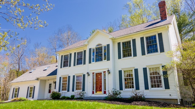 196 Eaton Ridge Dr, Holden, ME 04429 - colonial house featuring a chimney, roof with shingles, and a front lawn