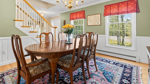 196 Eaton Ridge Dr, Holden, ME 04429 - dining space with a chandelier, ornamental molding, wood finished floors, a baseboard radiator, and wainscoting