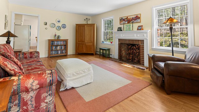 196 Eaton Ridge Dr, Holden, ME 04429 - living room with wood finished floors, a fireplace, and baseboard heating