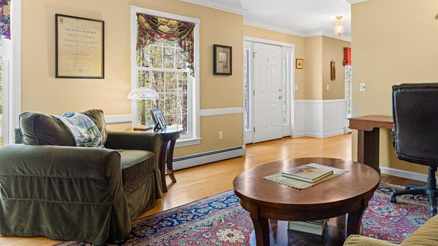196 Eaton Ridge Dr, Holden, ME 04429 - living area with a baseboard radiator, wood finished floors, ornamental molding, a wainscoted wall, and an office area