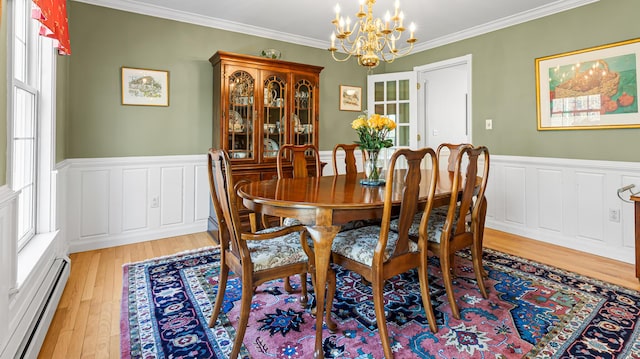 196 Eaton Ridge Dr, Holden, ME 04429 - dining space with a baseboard heating unit, a chandelier, light wood-style floors, wainscoting, and ornamental molding