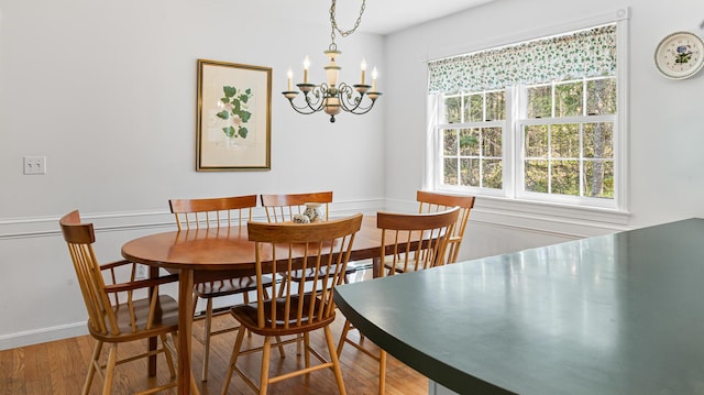 196 Eaton Ridge Dr, Holden, ME 04429 - dining area with a chandelier, wood finished floors, and baseboards