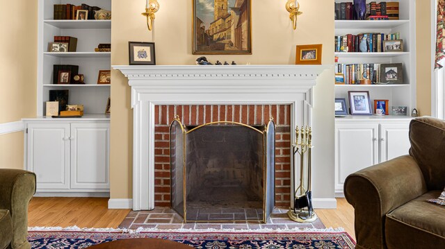196 Eaton Ridge Dr, Holden, ME 04429 - living room with a brick fireplace, light wood-type flooring, and built in shelves