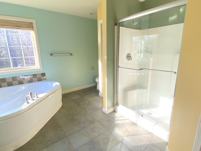 full bathroom featuring toilet, a shower stall, a garden tub, baseboards, and tile patterned flooring