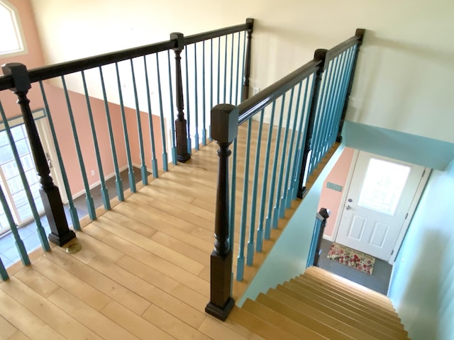 staircase featuring wood finished floors and plenty of natural light