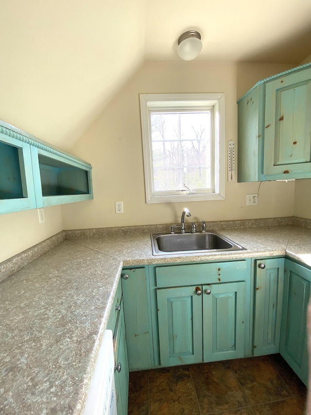 kitchen featuring a sink, green cabinetry, and vaulted ceiling