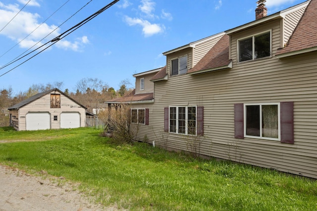 20 Crystal Spring Ln, Rome, ME 04963 - view of side of property with a detached garage, a chimney, a yard, an outbuilding, and roof with shingles