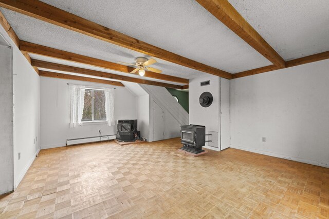 20 Crystal Spring Ln, Rome, ME 04963 - unfurnished living room featuring a wood stove, baseboard heating, beamed ceiling, a textured ceiling, and baseboards
